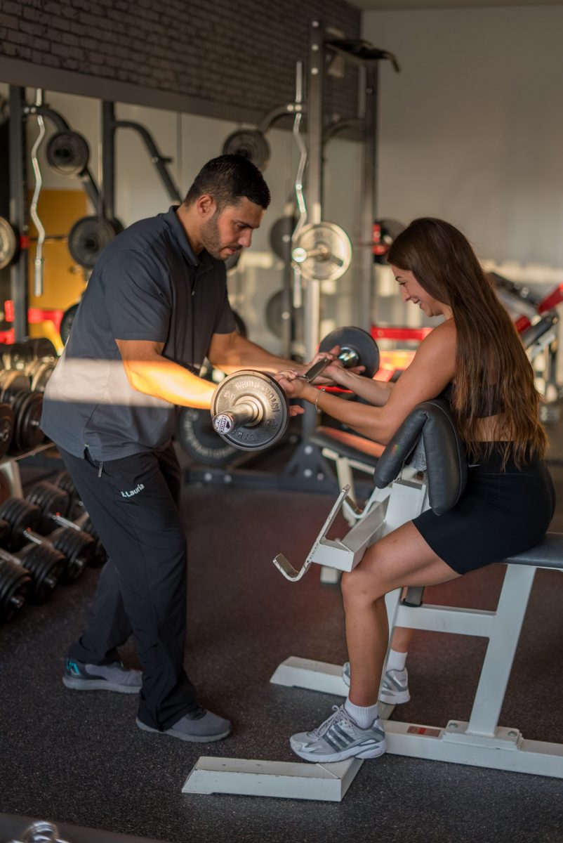 Trainer unterstützt beim Krafttraining im ComeFit Studio